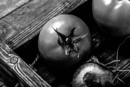 Fresh vegetables in a burned rustic texture box for background. Rough weathered wooden board. Toned.の写真素材