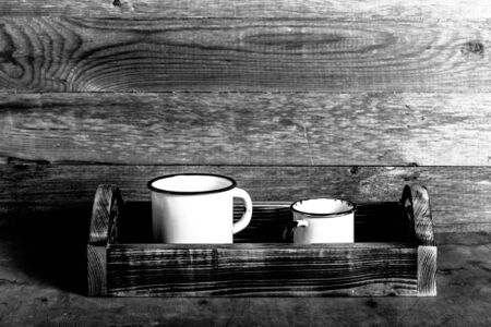 Old metal enamelware and handmade wooden box on the retro table. Toned.の写真素材