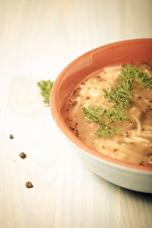 Homemade soup with noodles and meatballs on a wooden table. Traditional rural dinner. Toned.の写真素材