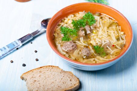 Homemade soup with noodles and meatballs on a wooden table. Traditional rural dinner.の写真素材