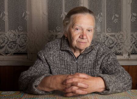 Portrait of elderly woman in rustic interior.の写真素材