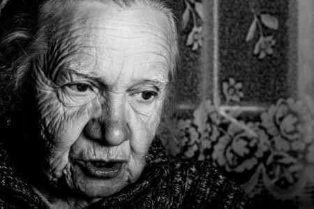 Portrait of elderly woman in rustic interior. Toned.の写真素材
