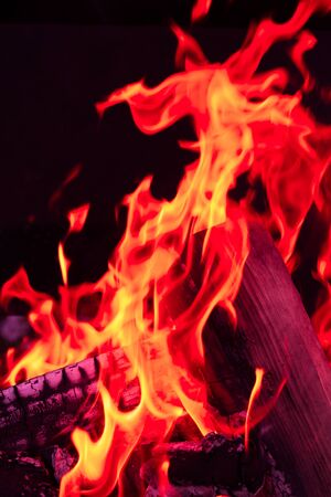 Burning wood logs, cooking on fire, warm evening, sparkles in the air, warm air from the fireの写真素材