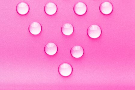 Drops of water on a color background. Pink. Toned.