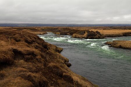 River and stunted grass on a dramatic landscape of Iceland.