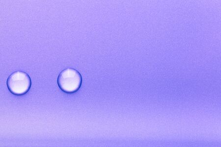 Drops of water on a color background. Violet. Toned.