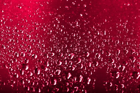 Drops of water on a glass background. Red. Selective focus. Toned.