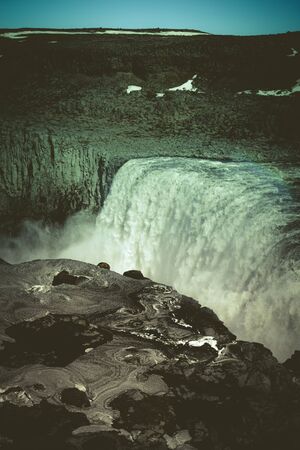 Stormy water and dirty spring snow. Beautiful view to the Dettifoss waterfall in Iceland. Toned.