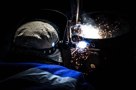 An experienced welder at work. Preparation and welding process of cast iron furnace. Selection...