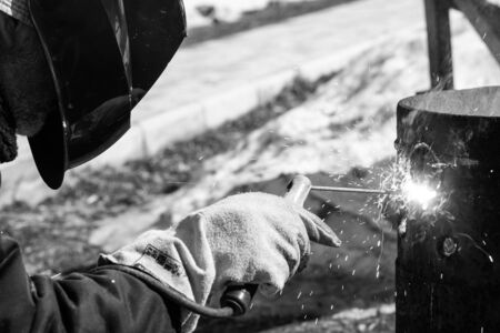 An experienced welder at work. Preparation and welding process of cast iron furnace. Selection focus. Shallow depth of field. Toned.の写真素材
