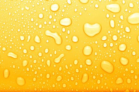 Drops of water on a color background. Selective focus. Yellow. Toned.の写真素材