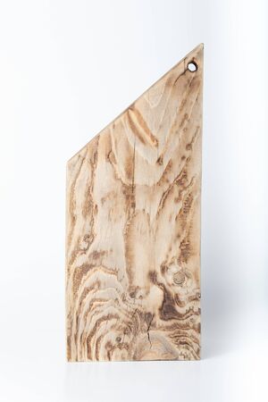 Handmade burned cutting board on a light background. Rough weathered wooden board.