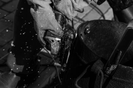 An experienced welder at work. Preparation and welding process of cast iron furnace. Selection focus. Shallow depth of field. Toned.の写真素材
