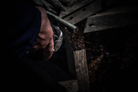 An experienced welder at work. Preparation and welding process of cast iron furnace. Selection focus. Shallow depth of field. Toned.の写真素材