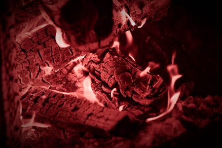 Burning wood logs, cooking on fire, warm evening, sparkles in the air, warm air from the fire. Toned.の写真素材