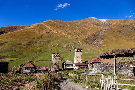 View of the village of Ushguli in a beautiful autumn landscape with white clouds in Svaneti....