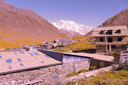 View of the village of Ushguli in a beautiful autumn landscape with white clouds in Svaneti....