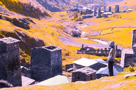 Old stone houses and fences of the village of Ushguli in a beautiful autumn landscape with white clouds in Svaneti. Georgia. Toned.の写真素材