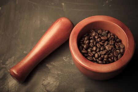 Composition with a coffee beans on a textured plastered background with a variety of arbitrary stains. Toned.の写真素材