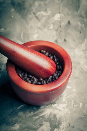 Composition with a coffee beans on a textured plastered background with a variety of arbitrary stains. Toned.の写真素材