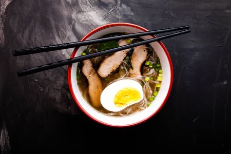 Composition with a bowl of rice noodles, meat and vegetables. Toned.の写真素材