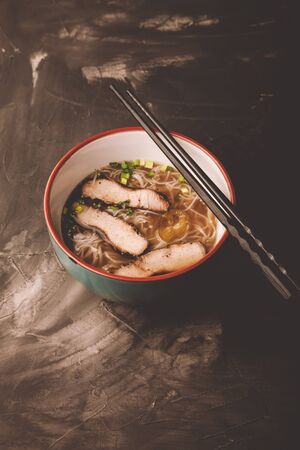 Composition with a bowl of rice noodles, meat and vegetables. Toned.の写真素材