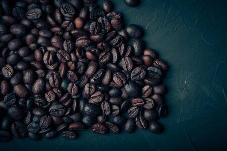Composition with a coffee beans on a textured plastered background with a variety of arbitrary stains. Toned.の写真素材