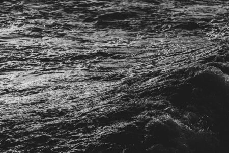 Surface of a calm sea on a sunset. Selective focus. Shallow depth of field. Toned.の写真素材