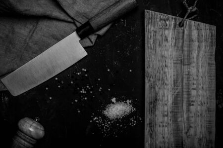 Chopping knives and spices on a dark table. Toned.
