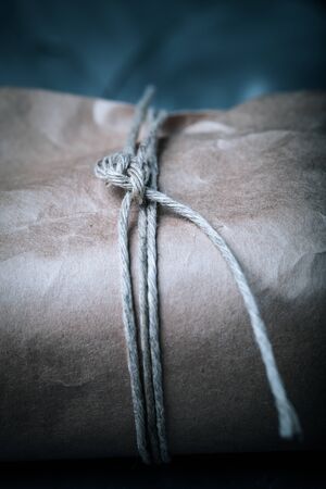 Composition with a rope and paper on a textured plastered surface. Toned.