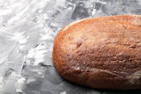 Composition with a bread on a textured plastered surface.