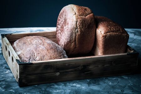 Composition with a bread on a textured plastered surface. Toned.