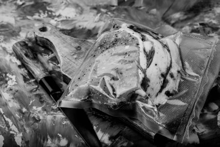 Composition with a meat prepared for cooking on a textured plastered surface. Toned.