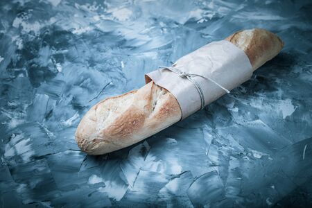 Composition with a bread on a textured plastered surface. Toned.の写真素材