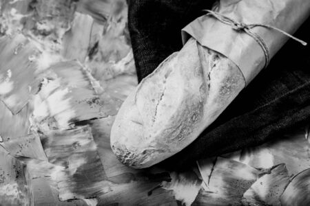 Composition with a bread on a textured plastered surface. Toned.の写真素材