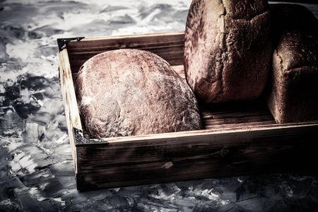 Composition with a bread on a textured plastered surface. Toned.の写真素材