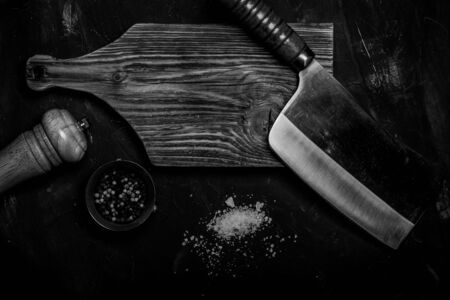 Chopping knives and spices on a dark table. Toned.の写真素材