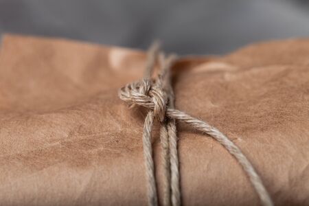 Composition with a rope and paper on a textured plastered surface.