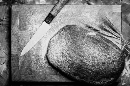 Composition with a bread on a textured plastered surface. Toned.