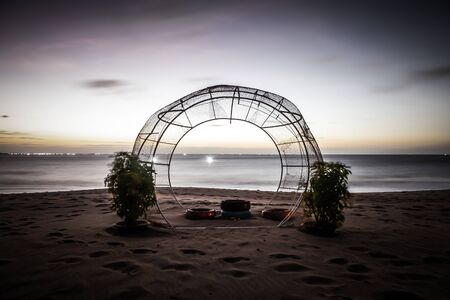 Sunshine on a sandy beach with a arch on a territory of hotel on a coast of the South China Sea. Toned.の写真素材