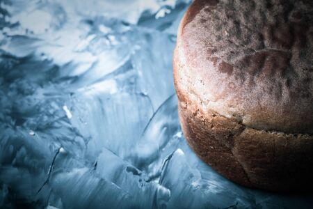 Composition with a bread on a textured plastered surface. Toned.
