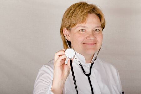Woman doctor with phonendoscope on her neck smiles for you.