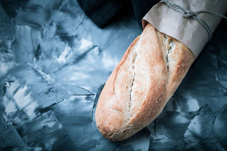 Composition with a bread on a textured plastered surface. Toned.の写真素材