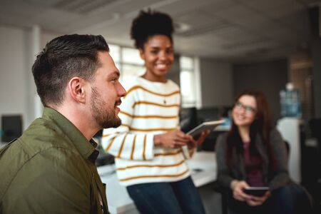 Portrait of a successful businessman with two female coworkers at background in the officeの写真素材