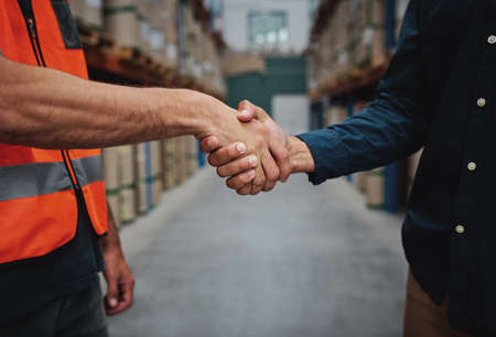 Close-up of two men handshake while concluding agreement about container rent and shaking handsの写真素材