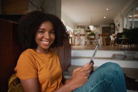 Portrait of cheerful happy woman relaxing at home using digital tablet