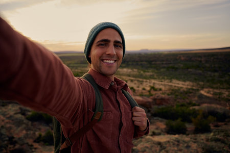 Young hiker on mountain during morning sunrise smiling and feeling fresh looking at cameraの写真素材