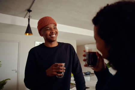 Mixed race couple drinking coffee. Young, happy African American male smiling at his female partner....