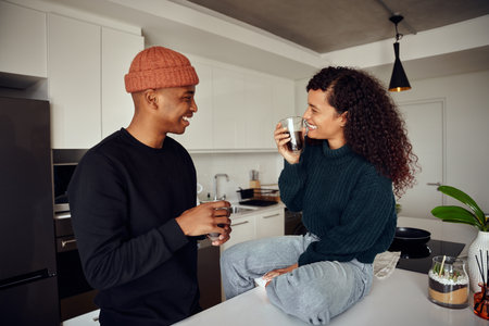 African American couple drinking coffee. Mixed race couple looking each other in the kitchen. High quality photoの写真素材