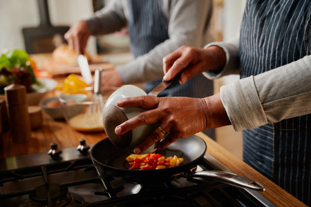 Hands of multi-cultural elderly couple cooking healthy breakfast together in kitchen at stove.の写真素材